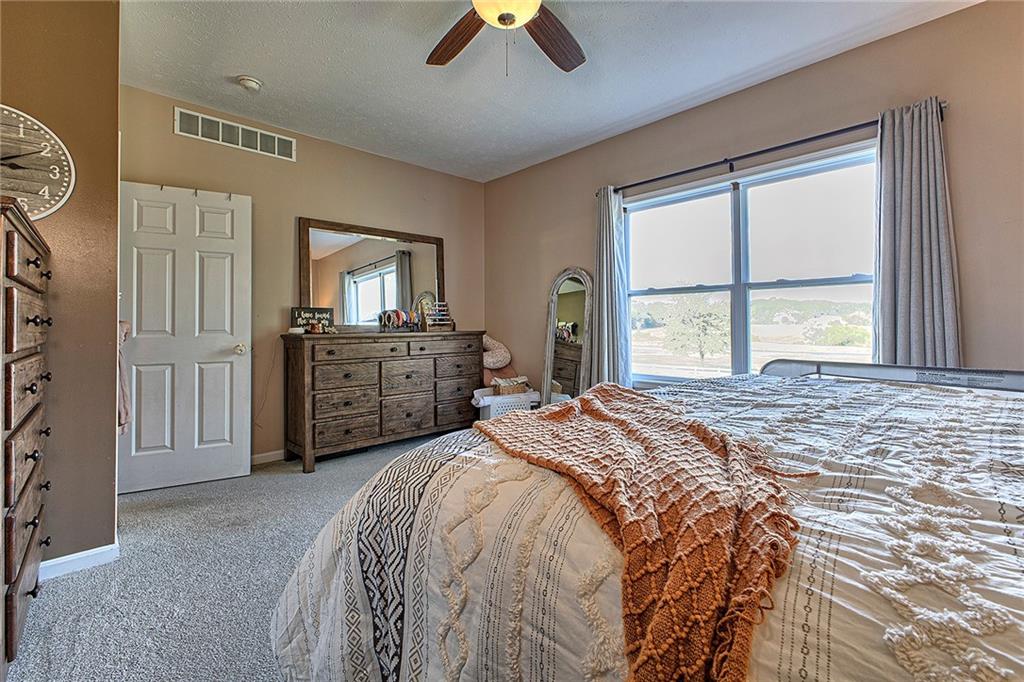 142 Lentz Road Latrobe, PA 15650 - Photo 19 of 32 a spacious bedroom with a bed a dresser and a chandelier