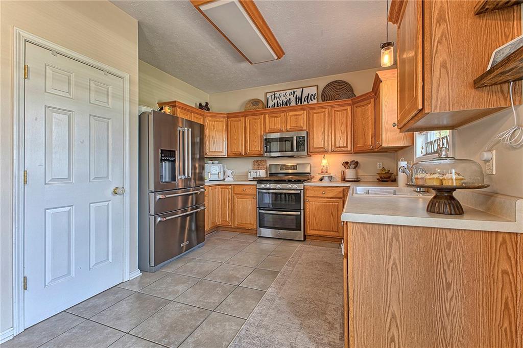 142 Lentz Road Latrobe, PA 15650 - Photo 6 of 32 a kitchen with stainless steel appliances granite countertop a refrigerator sink and cabinets