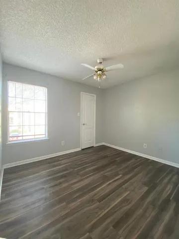 an empty room with wooden floor and window