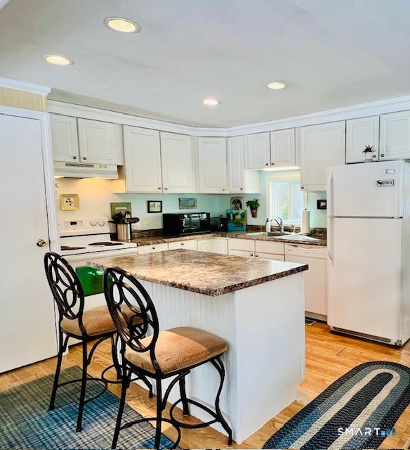 19 Old Forge Road Westbrook, CT 06498 - Photo 4 of 16 a kitchen with granite countertop a table chairs stove top oven and refrigerator