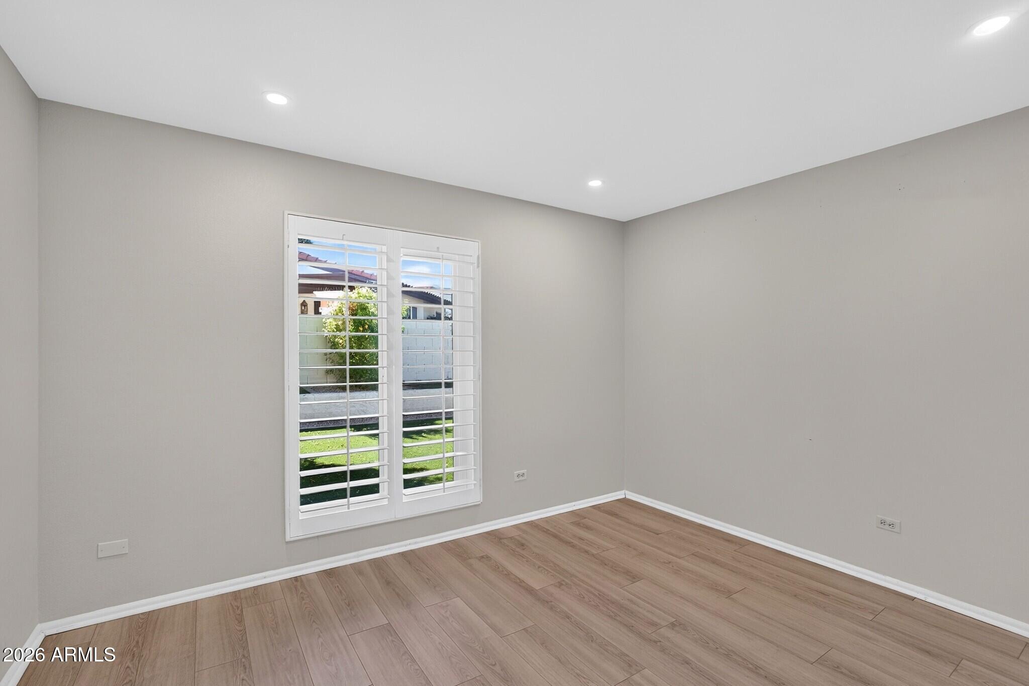 4615 East Monte Way Phoenix, AZ 85044 - Photo 24 of 35 a view of an empty room with wooden floor and a window