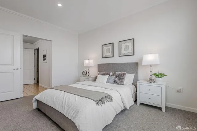 a bedroom with a bed and a lamp on dresser