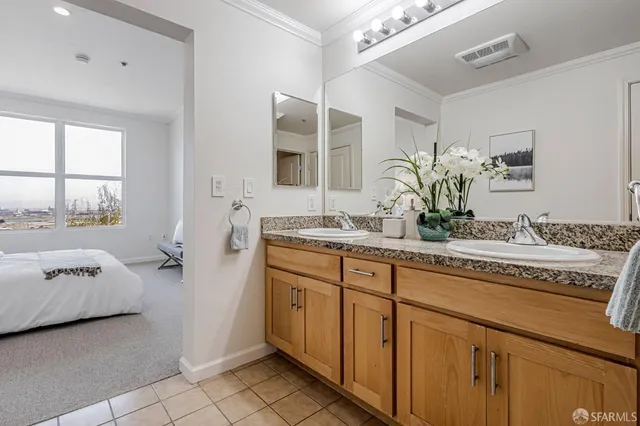a en suite bathroom with a granite countertop sink and a mirror