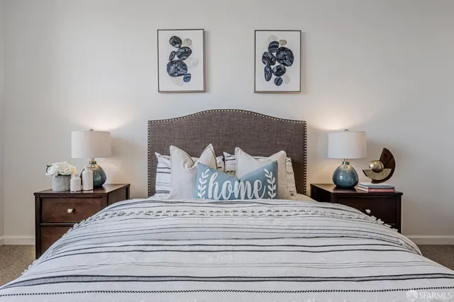 a bedroom with a bed and a lamp on dresser