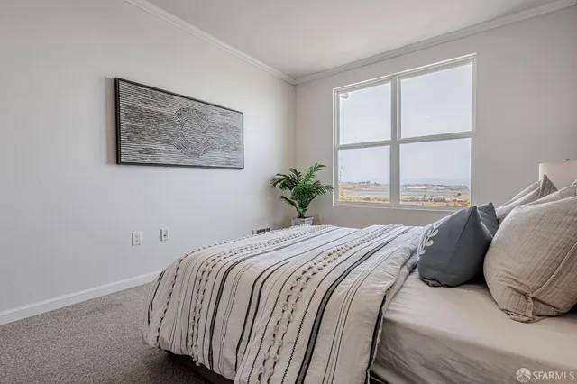 a bedroom with a bed and a large window