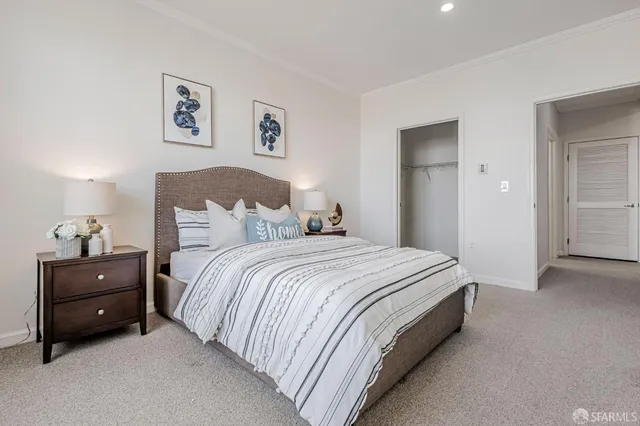 a bedroom with a bed and a lamp on dresser