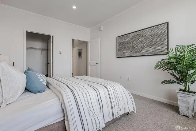 a bedroom with a bed and a potted plant