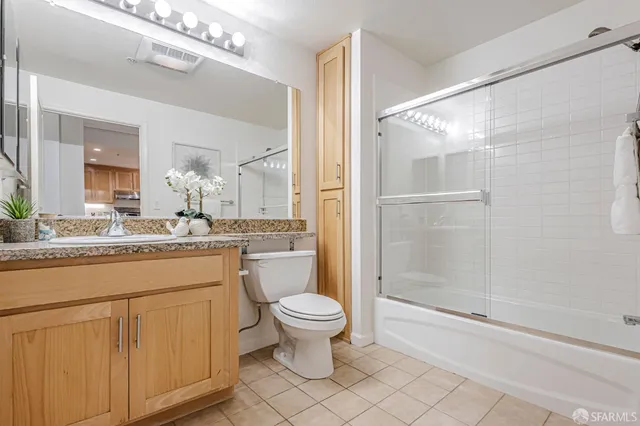 a bathroom with a granite countertop sink a toilet and shower