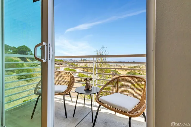 a view of a balcony with chairs and a potted plant