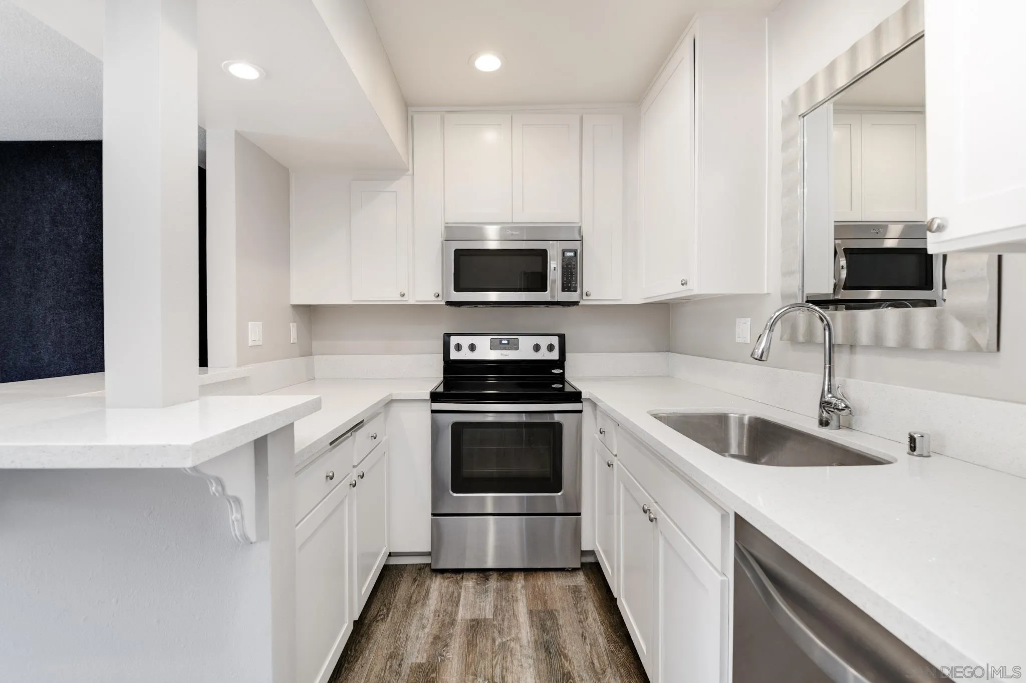 a kitchen with granite countertop a sink and a stove top oven