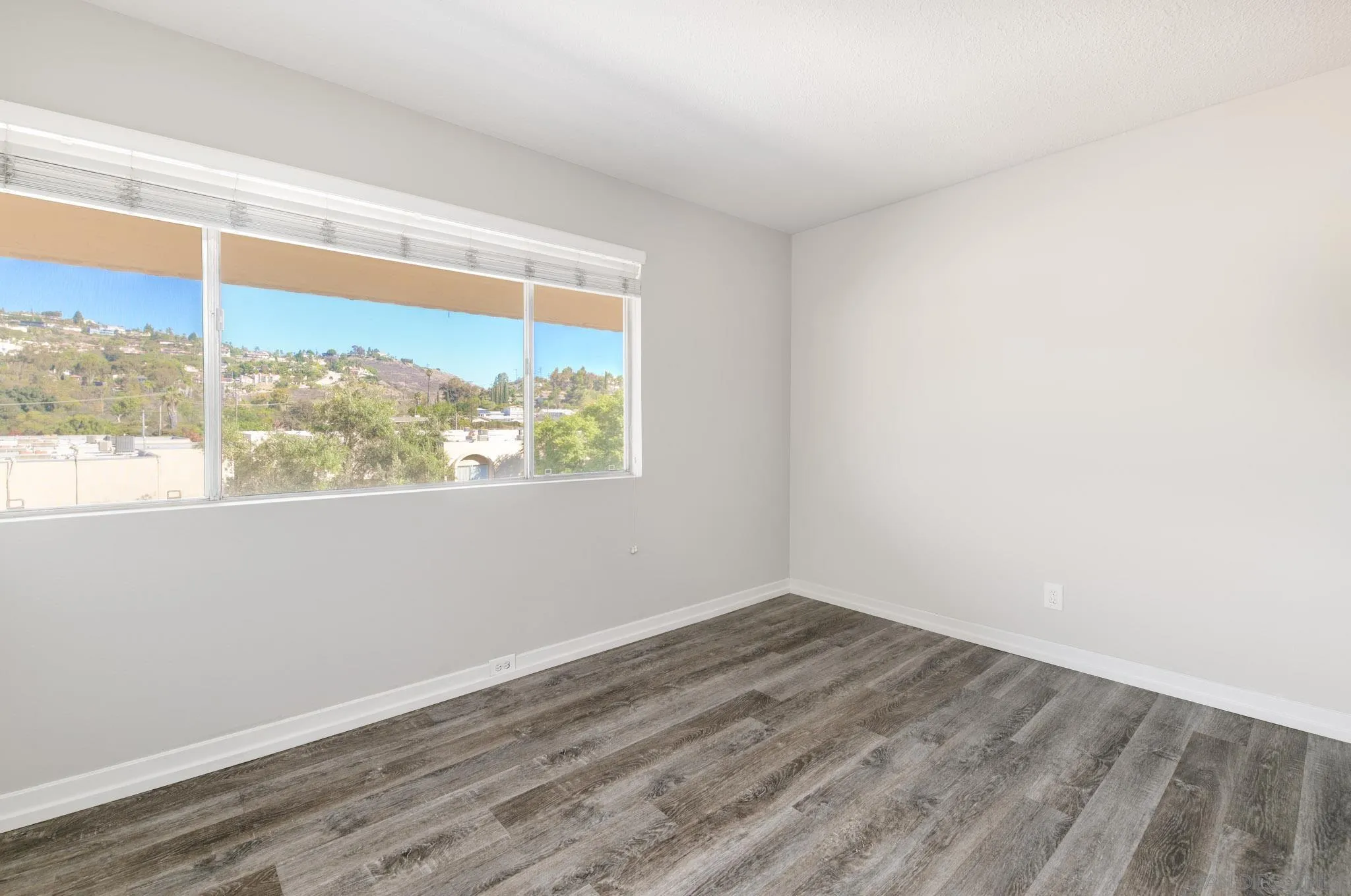 6775 Alvarado Road, Unit 21 San Diego, CA 92120 - Photo 17 of 27 an empty room with wooden floor and windows