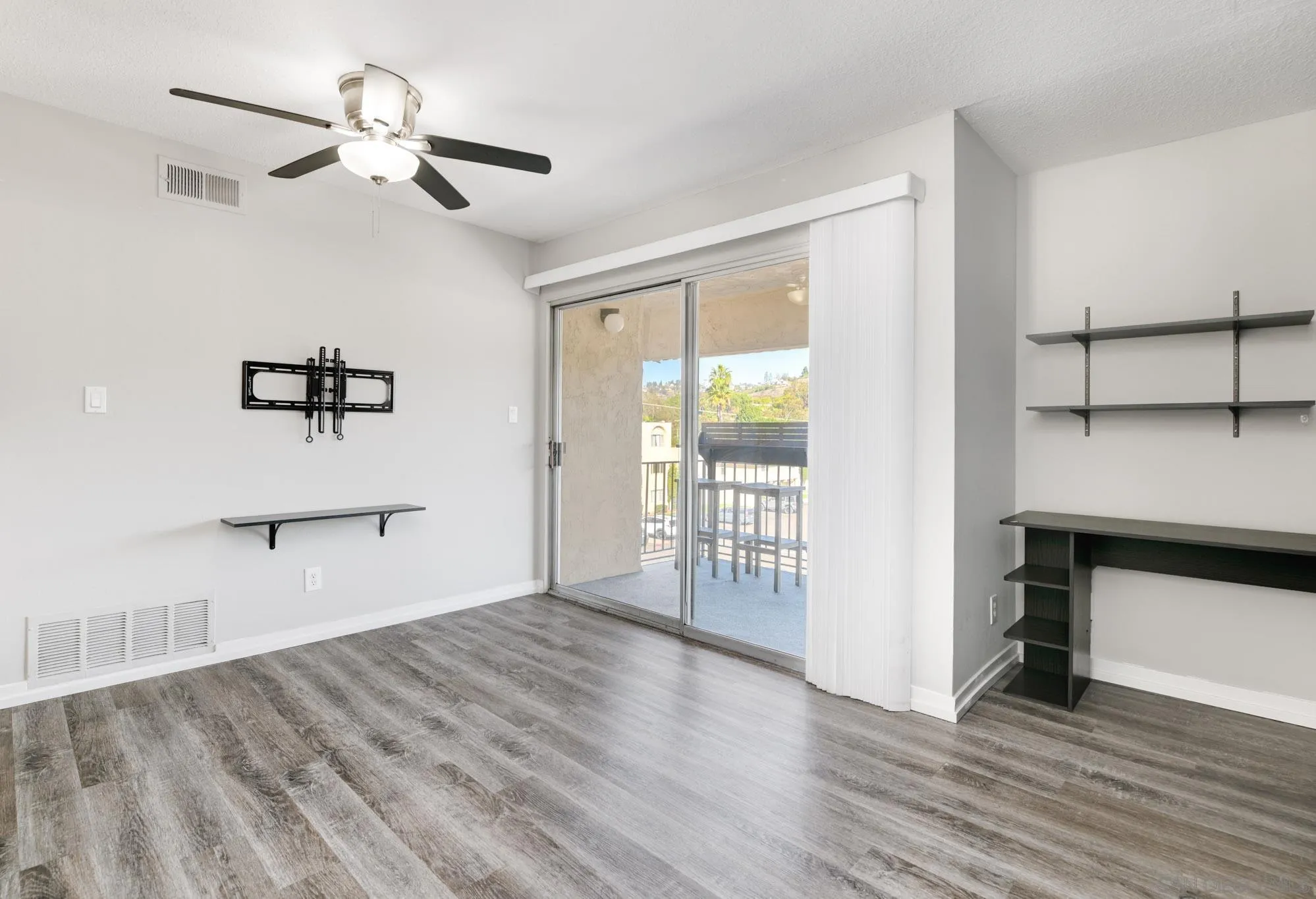 6775 Alvarado Road, Unit 21 San Diego, CA 92120 - Photo 5 of 27 a view of an empty room with a window and wooden floor