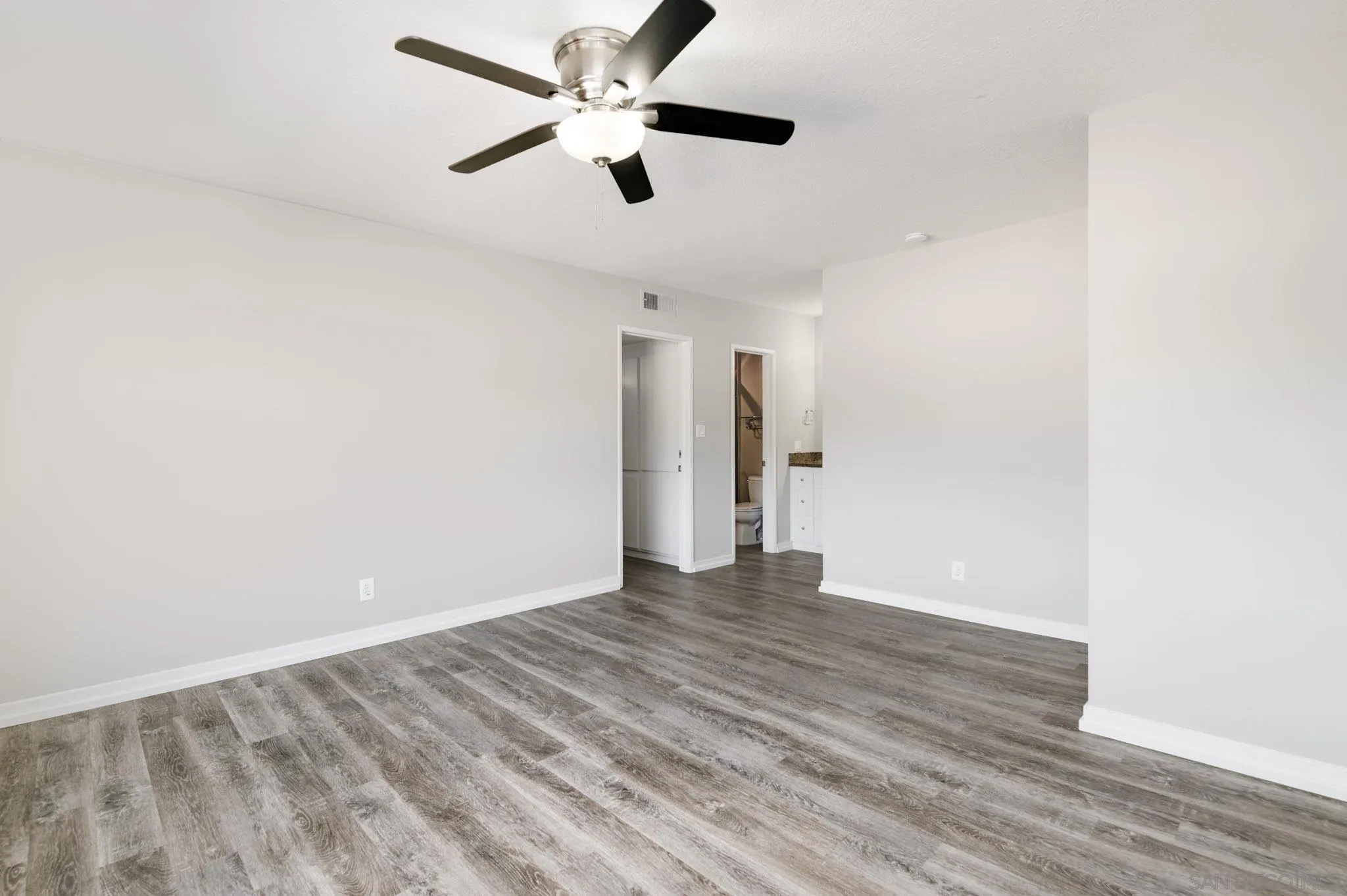 6775 Alvarado Road, Unit 21 San Diego, CA 92120 - Photo 10 of 27 an empty room with wooden floor and a ceiling fan