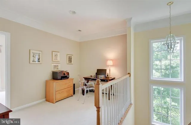 a view of a workspace with furniture and a window