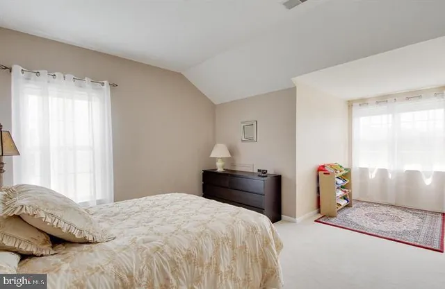 a bedroom with a bed and dresser with mirror