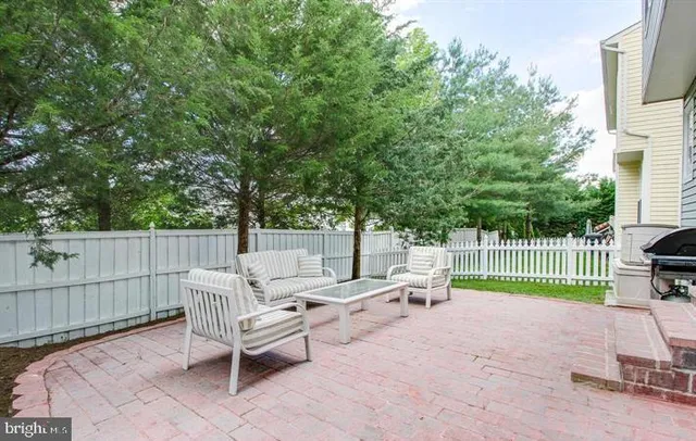 a backyard of a house with barbeque oven and fence
