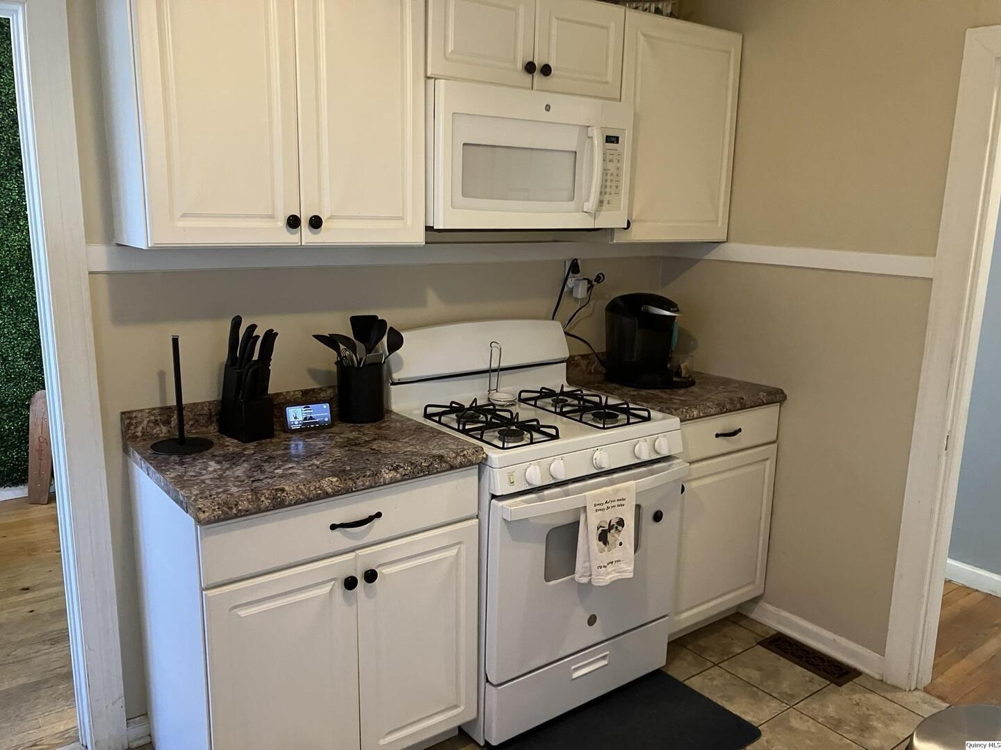 2415 Larch Road Quincy, IL 62301 - Photo 4 of 18 a kitchen with granite countertop white cabinets and a stove top oven