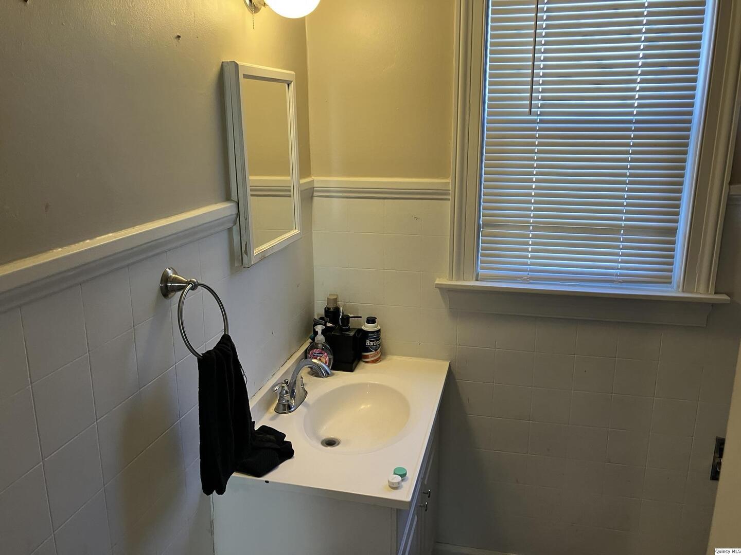 2415 Larch Road Quincy, IL 62301 - Photo 6 of 18 a bathroom with a sink and a mirror