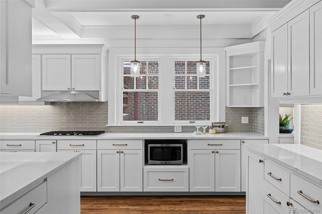 a kitchen with stainless steel appliances granite countertop a stove a sink and white cabinets