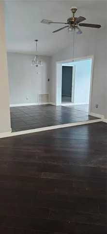 a view of a room with wooden floor and fan