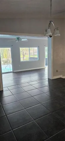a view of empty room with window and wooden floor