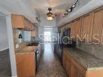 a kitchen with granite countertop a sink a stove and refrigerator