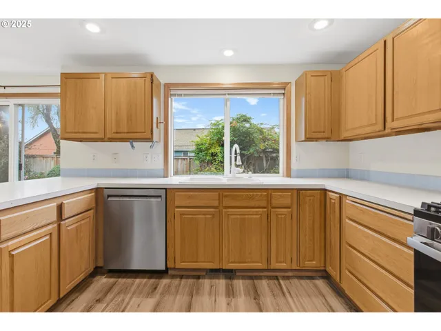 a kitchen with stainless steel appliances granite countertop a sink stove and cabinets