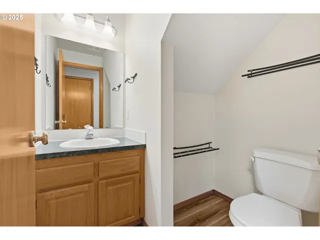 a bathroom with a granite countertop toilet sink and mirror