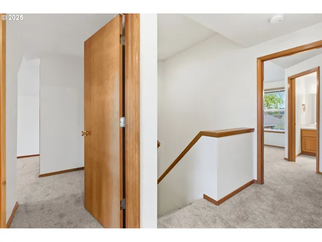 a view of a hallway with wooden floor and entryway