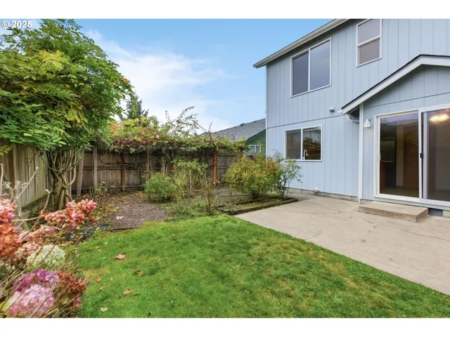 a view of a backyard with a garden and entertaining space