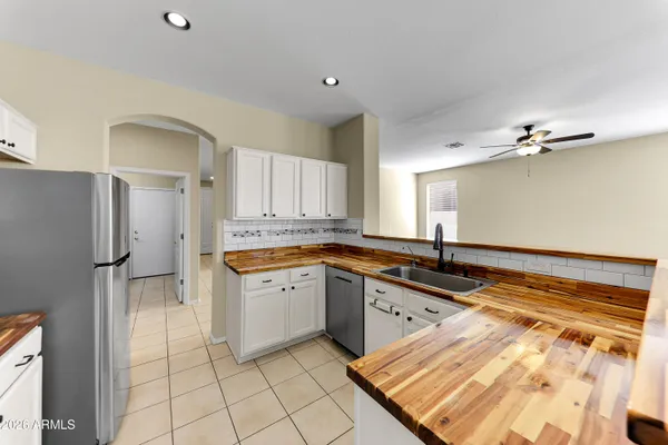 a large kitchen with granite countertop a sink and cabinets