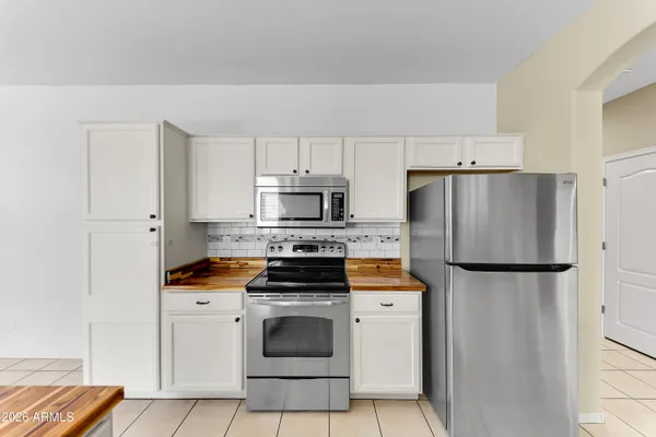 a kitchen with stainless steel appliances a refrigerator stove and white cabinets