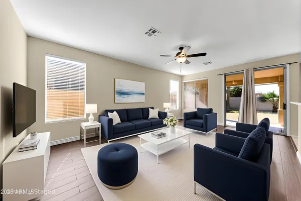 a living room with furniture a ceiling fan and a flat screen tv