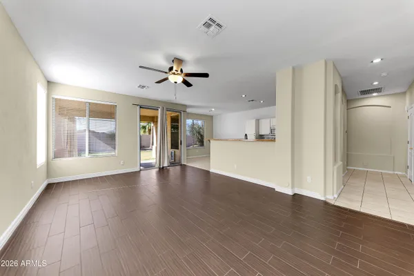 a view of an empty room with window and wooden floor