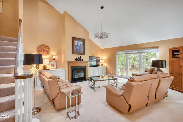 a living room with furniture and large windows with outer view