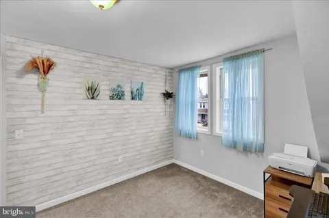 a bedroom with a baby bed a couch and dresser