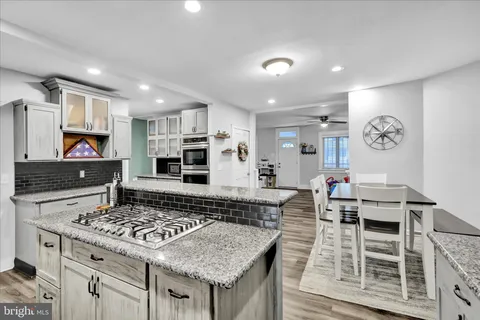 a kitchen with stainless steel appliances kitchen island granite countertop a stove a sink and a microwave