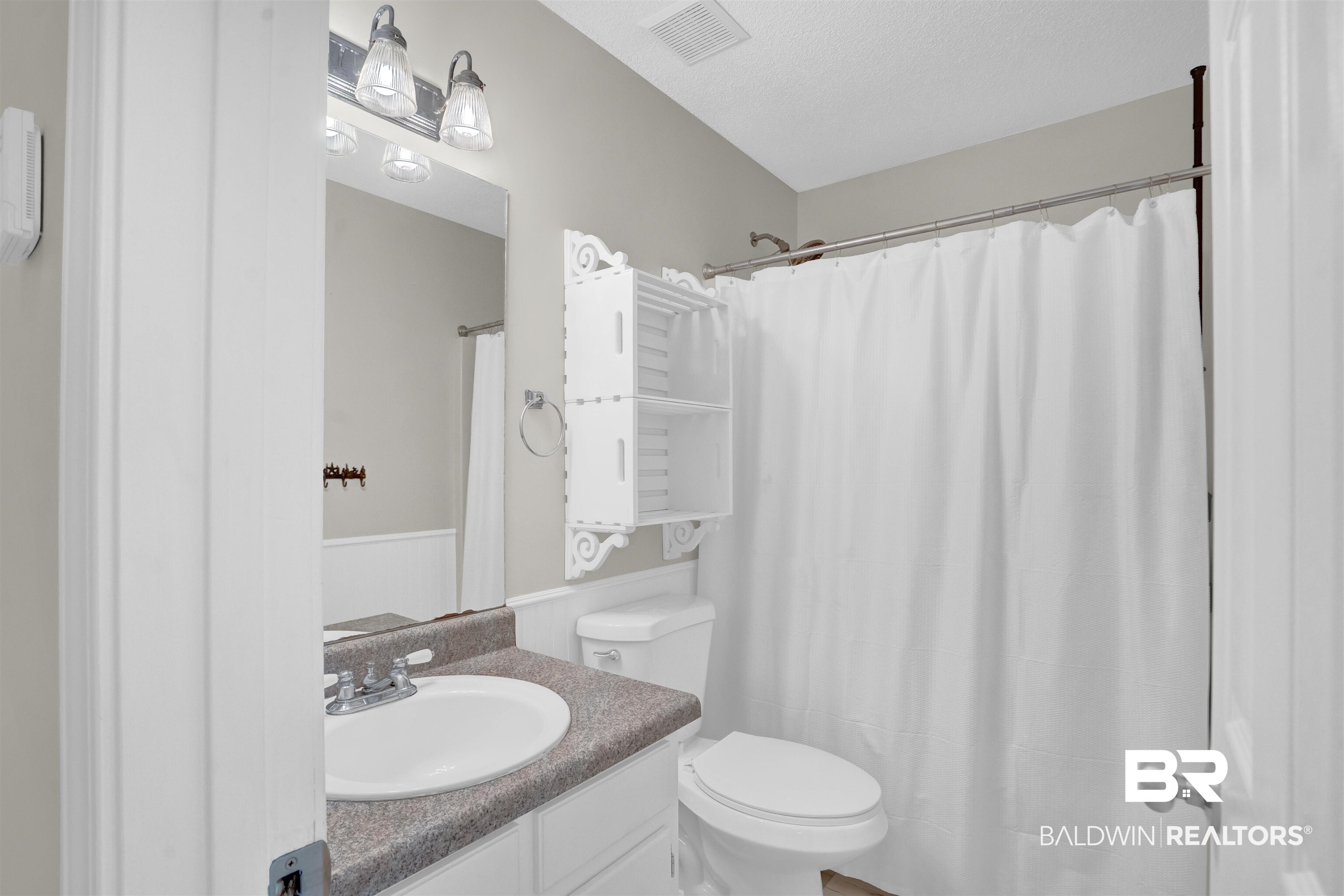 30871 Stanton Road Spanish Fort, AL 36527 - Photo 18 of 35 Bathroom featuring toilet, a textured ceiling, vanity, and a shower with curtain