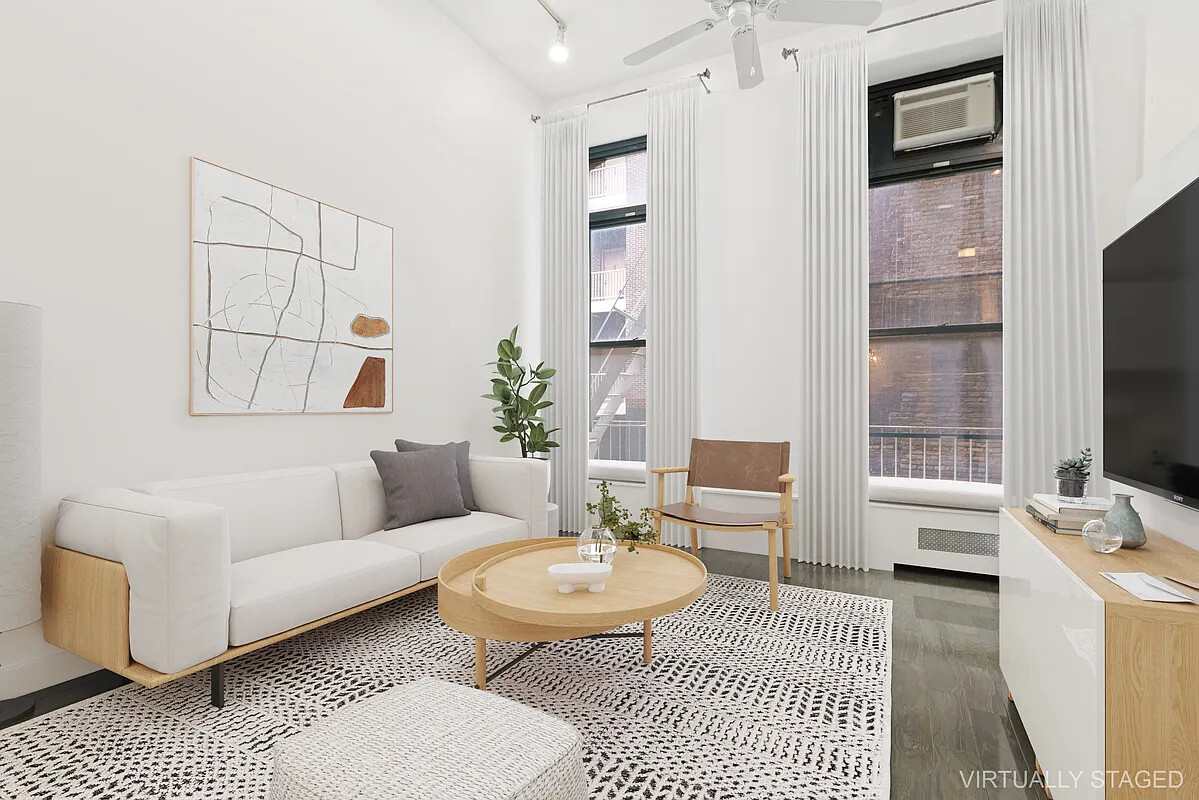 250 Mercer Street, Unit C318 Manhattan, NY 10012 - Photo 3 of 14 a living room with furniture a flat screen tv and a table
