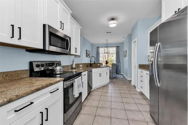 a kitchen with stainless steel appliances granite countertop a refrigerator sink and cabinets