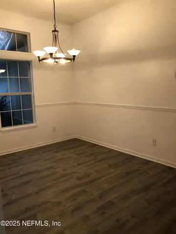 a view of a room with wooden floor and a window