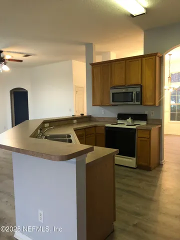 a kitchen with a sink a stove top oven and cabinetry