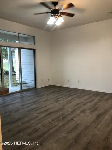 en empty room with wooden floor fan and window