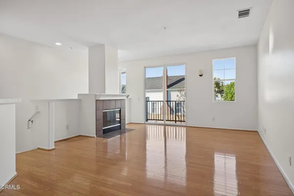 a view of an empty room with a fireplace and a window