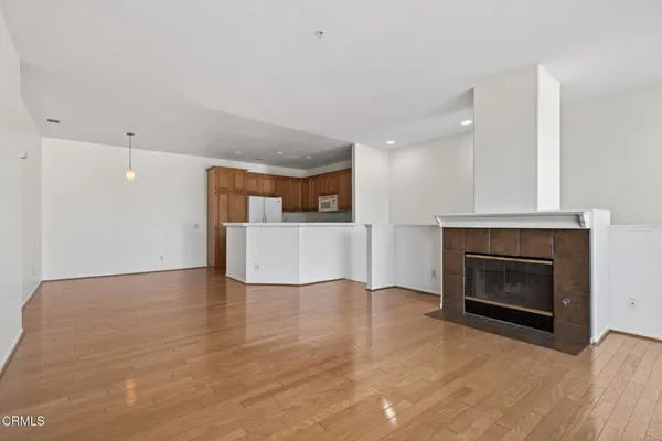 a view of a room with wooden floor and a ceiling fan