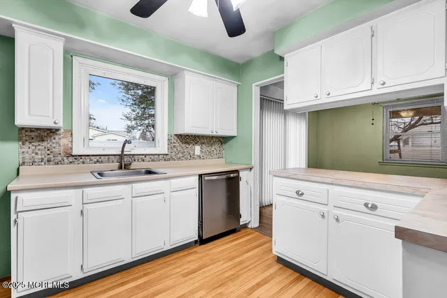 a kitchen with granite countertop white cabinets and white appliances