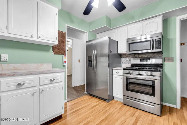 a kitchen with granite countertop a refrigerator and a stove top oven