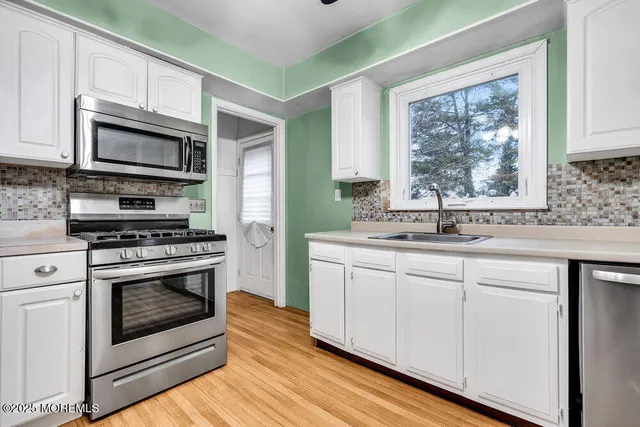 a kitchen with stainless steel appliances granite countertop a stove microwave and sink