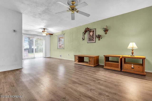 a view of a livingroom with wooden floor and a ceiling fan