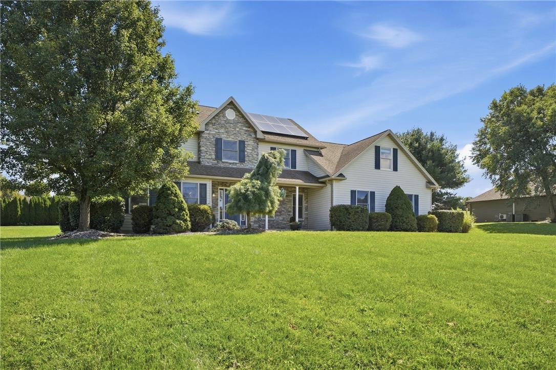590 Fehr Road Nazareth, PA 18064 - Photo 77 of 79 A spacious green lawn frames this multi-level home featuring solar panels and stone accents.